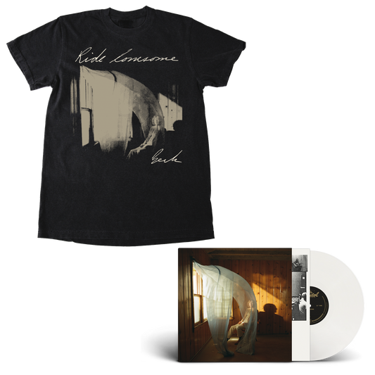 A Black Ride Lonesome Tee with the album cover on the chest and a white vinyl record partially pulled from its album sleeve, showing the cover art of Beck in a room with warm sunlight