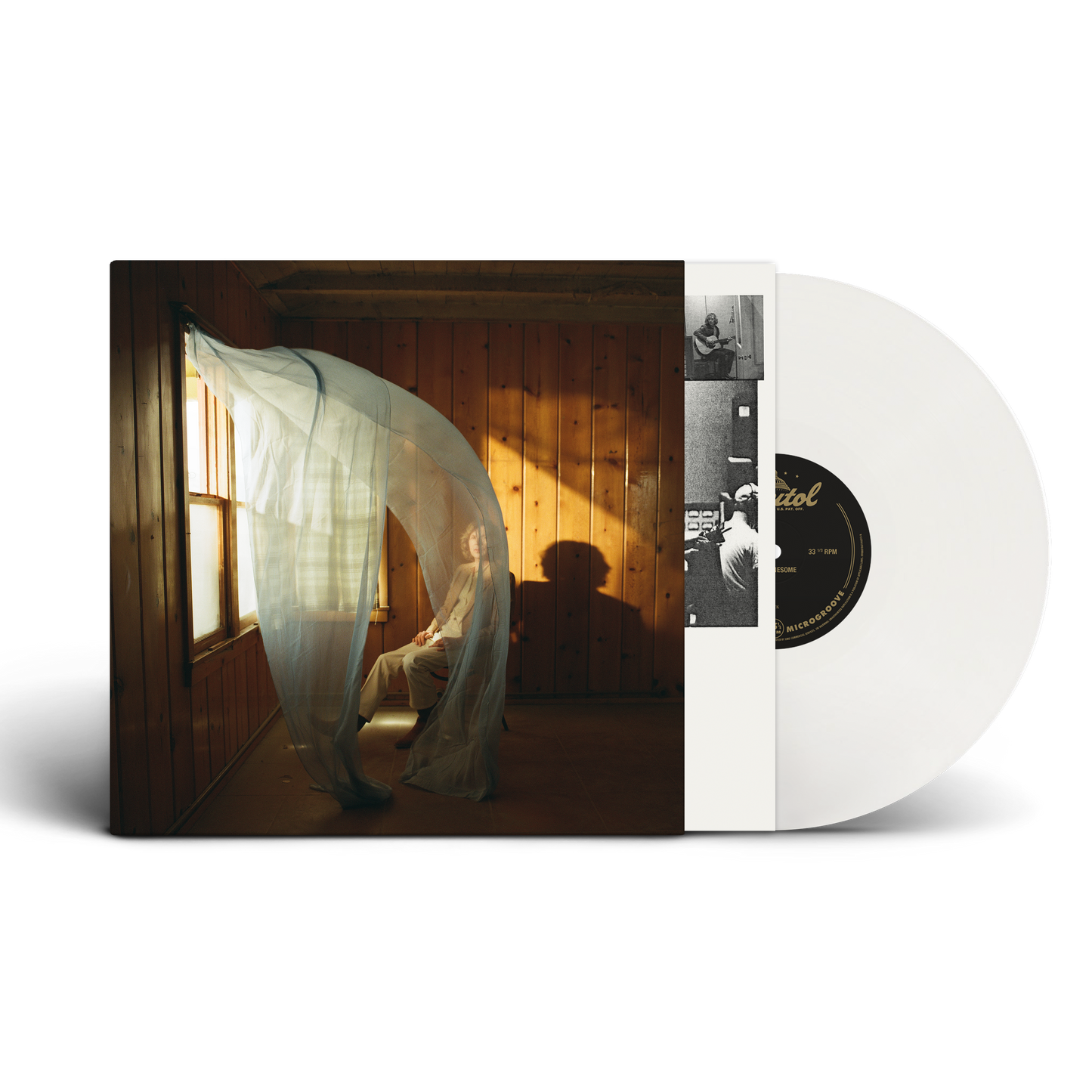 A white vinyl record partially pulled from its album sleeve, showing the cover art of Beck in a room with warm sunlight